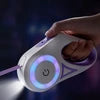 Retractable dog leash with glowing LED spotlight on handle in dark setting